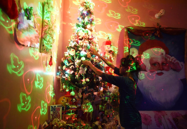 a pakistani christian decorates a christmas tree in karachi on december 24 2014 photo afp a pakistani christian decorates a christmas tree in karachi on december 24 2014 photo afp