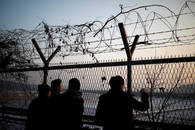 people look toward the north through a barbed wire fence near the militarized zone separating the two koreas in paju south korea december 21 2017 photo reuters