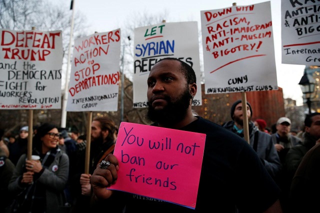 isaiah dupree holds a sign as demonstrators gather at washington square park to protest against us president donald trump in new york u s january 25 2017 photo reuters