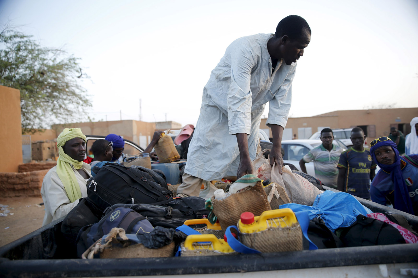 a man arranges the belongings of migrants into the back of a truck photo reuters