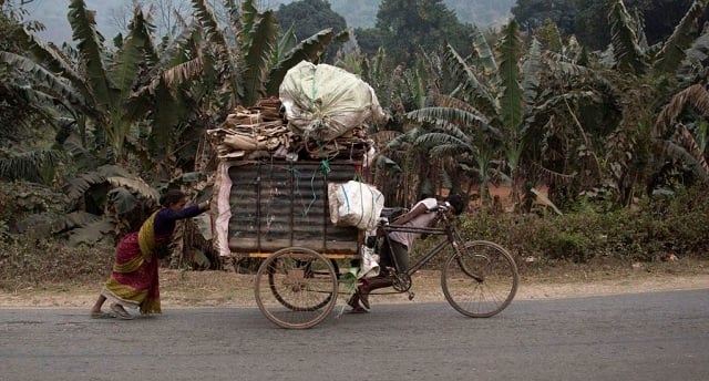 an indian poor family pulls a cart full of recyclable materials on a street to sale on the outskirts of gauhati india photo afp