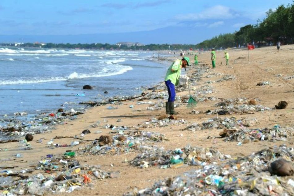 photo shows rubbish collectors clearing trash on kuta beach near denpasar on indonesia 039 s tourist island of bali photo afp