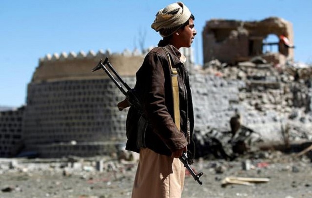 an armed yemeni inspects the damage following a reported saudi led coalition air strike on south sanaa photo afp