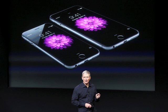 apple ceo tim cook stands in front of a screen displaying the iphone 6 during a presentation at apple headquarters in cupertino california october 16 2014 photo reuters
