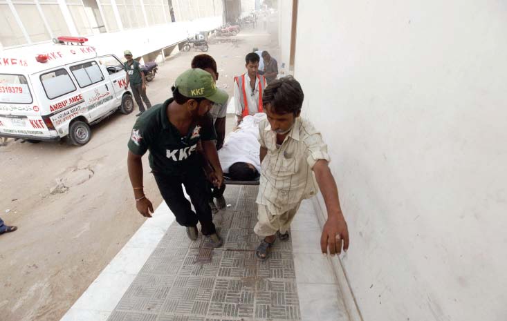 men from an ambulance service rush an injured person into the accident and emergency ward at abbasi shaheed hospital on friday the body count nearly doubled on the third day of violence photo athar khan express