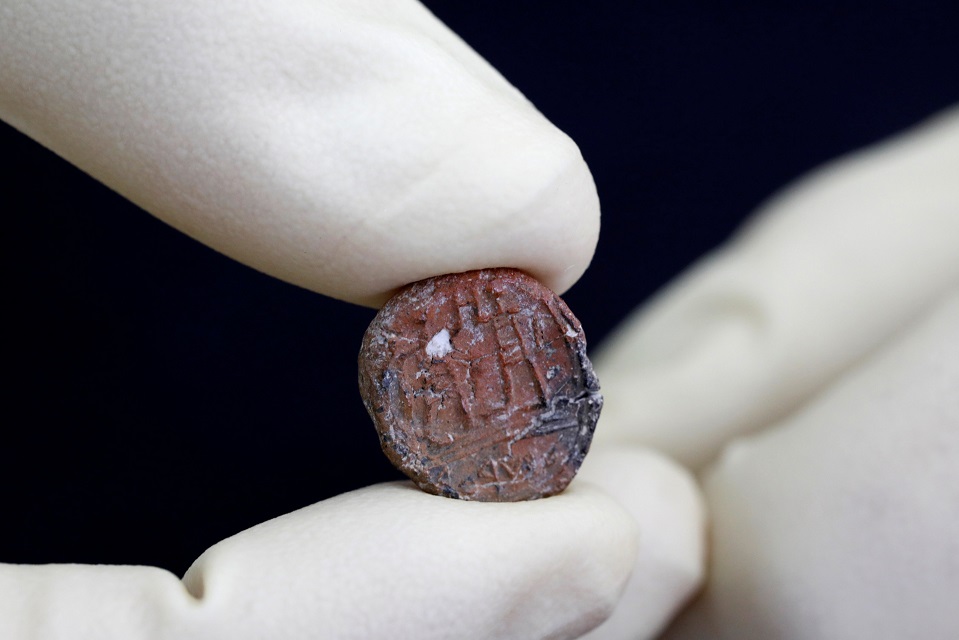 a conservator shows a 2 700 year old clay seal impression which archaeologists from the israel antiquities authority say belonged to a biblical governor of jerusalem and was unearthed in excavations in the western wall plaza in jerusalem 039 s old city january 1 2018 photo reuters