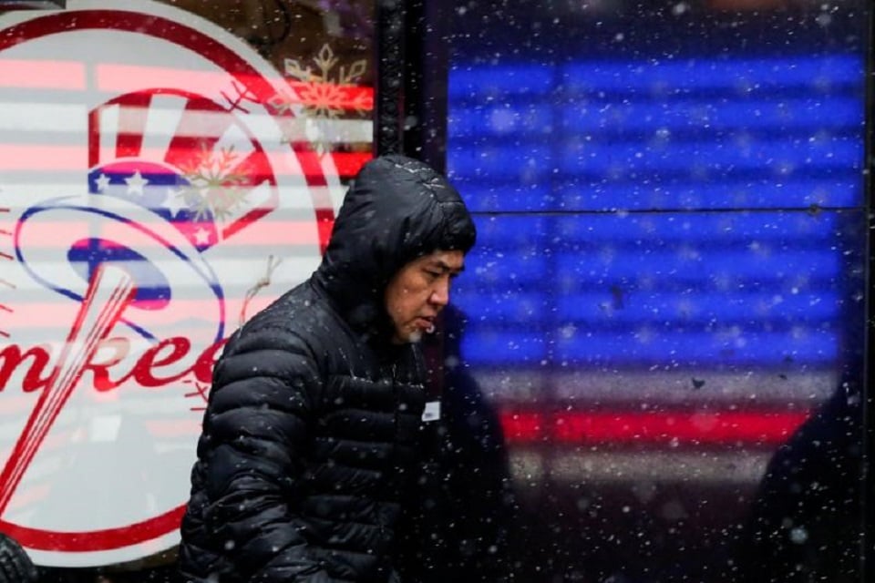 a man walks in falling snow at times square as a cold weather front hits the region in manhattan new york u s december 30 2017 photo reuters