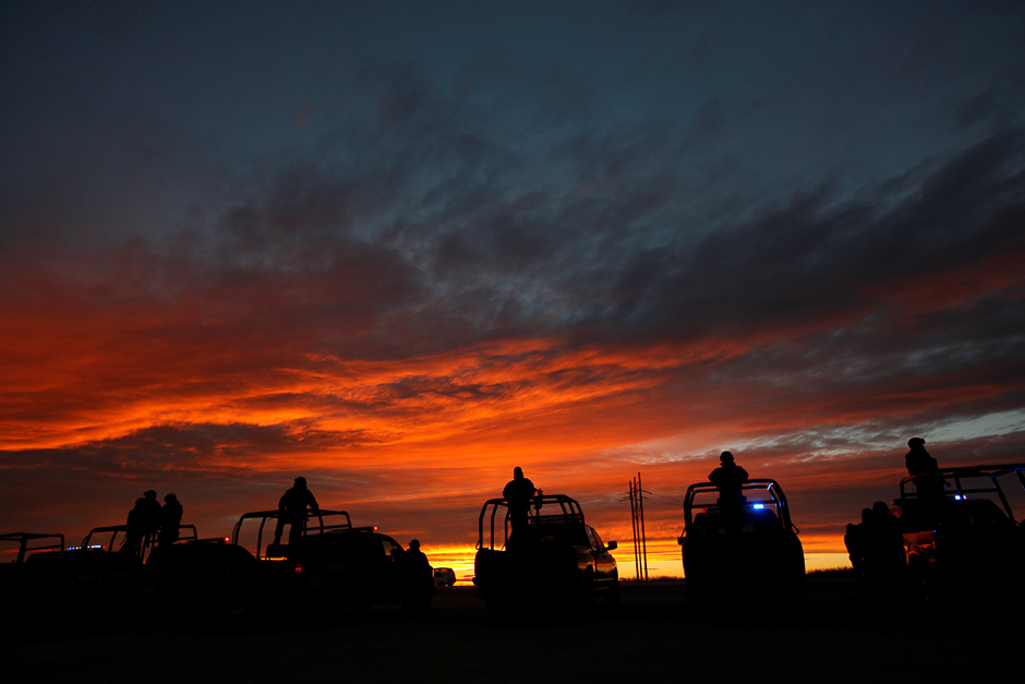 Federal police officers stand guard on top of pick up trucks near the jail where Mexican drug lord Joaquin 