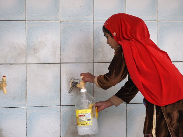 this picture taken on december 14 2017 shows a girl filling a bottle at a water filtration plant in islamabad photo afp this picture taken on december 14 2017 shows a girl filling a bottle at a water filtration plant in islamabad photo afp