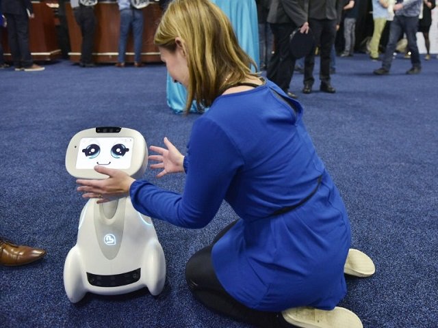 a woman plays with buddy the companion robot by blue frog robotics during the ces unveiled preview event in las vegas photo afp