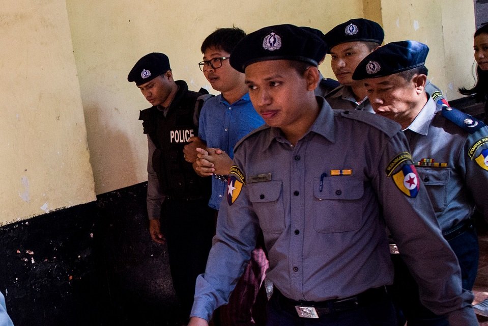 reuters journalist wa lone 2nd l is escorted by police after a court appearance in yangon on january 10 2018 myanmar police formally filed charges on january 10 against two reuters reporters accused of breaching the official secrets act a judge said an offence that carries up to 14 years in prison photo afp