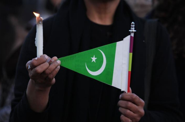 a woman holds a candle and a pakistani flag as she takes part in a protest against terrorism in islamabad photo reuters