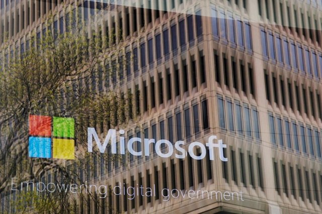 an promotional video plays behind a window reflecting a nearby building at the microsoft office in cambridge massachusetts us on may 15 2017 photo reuters