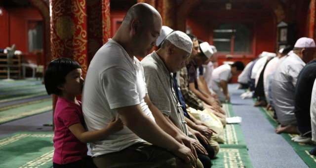 a little girl embraces a muslim man from behind as he prays with other devotees during the evening ramadan prayers on the first day of the fasting month of ramadan at the niujie mosque in beijing photo afp a little girl embraces a muslim man from behind as he prays with other devotees during the evening ramadan prayers on the first day of the fasting month of ramadan at the niujie mosque in beijing photo afp