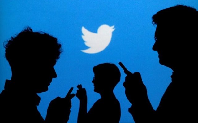 people holding mobile phones are silhouetted against a backdrop projected with the twitter logo in this illustration picture taken september 27 2013 photo reuters