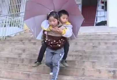 nine year old chinese girl carries disabled older brother to school on her shoulders every day