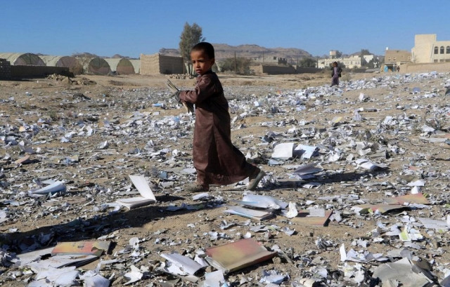 a boy holds a book as he walks on books scattered on the ground after an air strike hit a school book storage building in the northwestern city of saada yemen january 13 2018 photo reuters a boy holds a book as he walks on books scattered on the ground after an air strike hit a school book storage building in the northwestern city of saada yemen january 13 2018 photo reuters