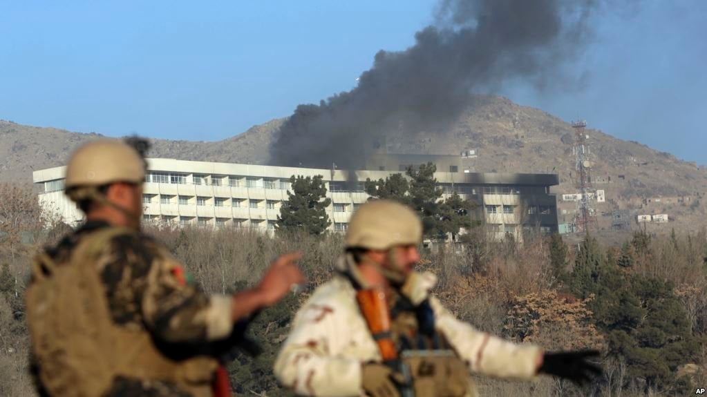 afghan security personnel stand guard as smoke rises from the intercontinental hotel after an attack in kabul photo afp