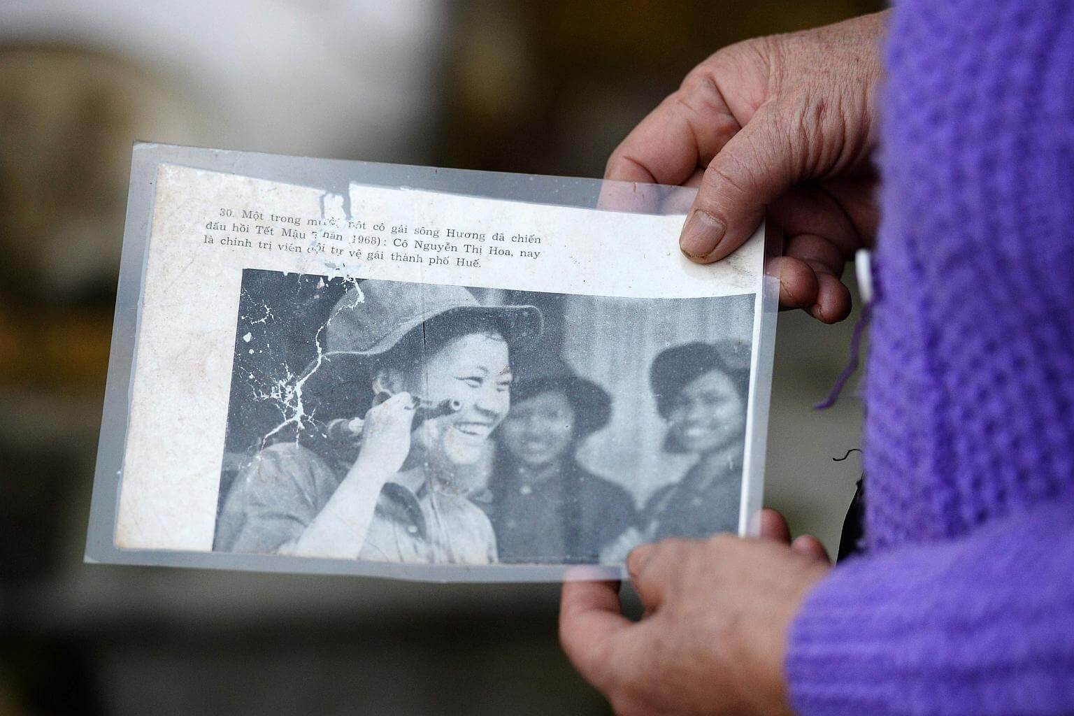 nguyen thi hoa stands next to a memorial plaque near the graves of four of her comrades killed during the 1968 tet offensive are located on the outskirts of hue photo afp