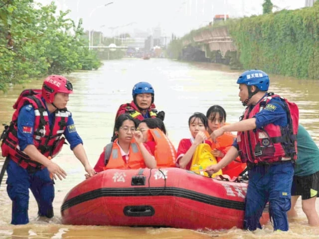 workers evacuate flood affected students in guigang in china s southern guangxi region photo afp workers evacuate flood affected students in guigang in china s southern guangxi region photo afp