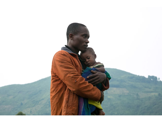 a congolese man holds his child after he crossed the border from the democratic republic of congo drc to be refugees at nteko village in western uganda on january 24 2018 photo afp