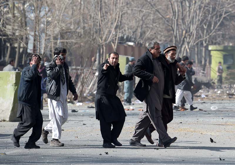 afghan volunteers help an injured men at the scene of a car bomb exploded in front of the old ministry of interior building in kabul on january 27 2018 an ambulance packed with explosives blew up in a crowded area of kabul on january 27 killing at least 17 people and wounding 110 others officials said in an attack claimed by the taliban photo afp