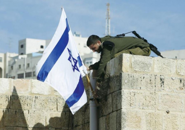 an israeli solider removes the flag from a rooftop in hebron as troops force jewish settlers out of homes they said they had purchased from palestinians photo reuters an israeli solider removes the flag from a rooftop in hebron as troops force jewish settlers out of homes they said they had purchased from palestinians photo reuters