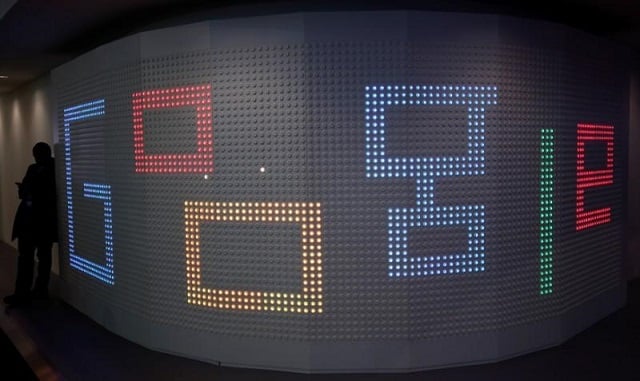 a man checks his mobile phone next to an illuminated panel at google stand during the mobile world congress in barcelona spain march 1 2017 photo reuters