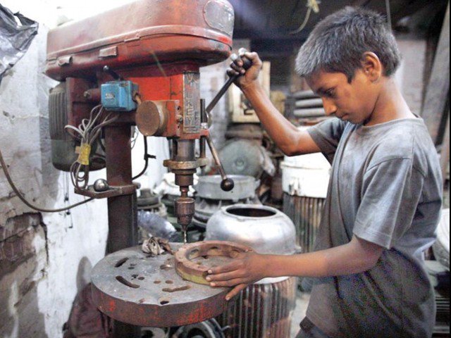 a child labourer operates a drill machine at a workshop in lahore photo app file