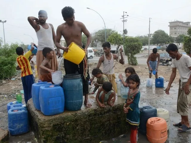 people filling their containers with water near korangi due to the shortage of water photo file people filling their containers with water near korangi due to the shortage of water photo file