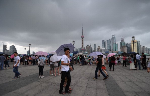 people walk along the bund as storm clouds gather over the huangpu river in shanghai on august 2 2012 photo reuters