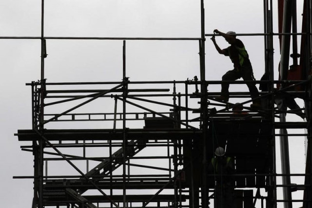 a man works on scaffolds at a construction site photo reuters a man works on scaffolds at a construction site photo reuters
