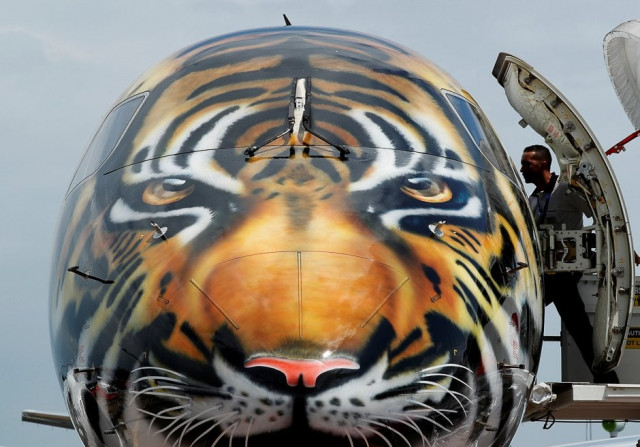 an embraer e 190 e2 aircraft featuring a spray painted tiger 039 s face on the nose of the aircraft is displayed during a media preview of the singapore airshow photo reuters
