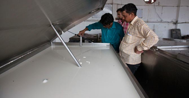 a farmer inspects the quality of milk in an industrial refrigerator at a farm in narowal photo reuters