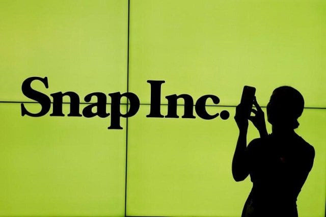 a woman stands in front of the logo of snap on the floor of the new york stock exchange nyse while waiting for snap to post their ipo in new york city new york us on march 2 2017 photo reuters