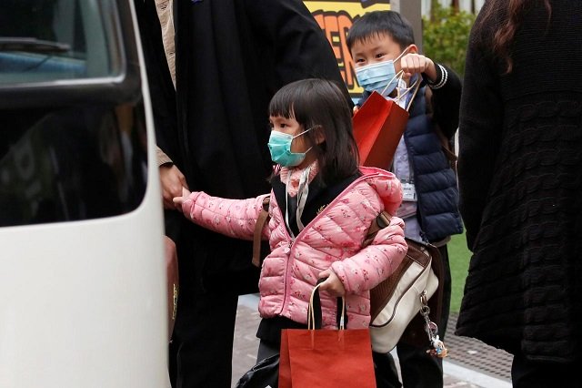 kindergarten students wearing masks to ward off flu get on a school bus as they leaves school in hong kong china february 7 2018 photo reuters