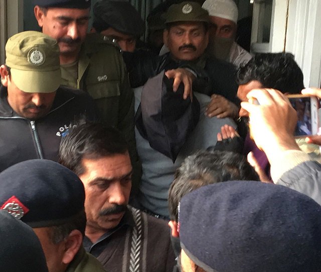 policemen escort the suspect accused of raping and murdering a young girl as they leave an anti terrorist court in lahore on january 24 2018 photo afp