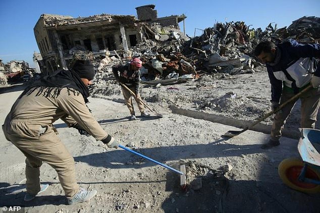 workers clean up debris from a street in mosul 039 s old city on january 8 2018 six months after iraqi forces seized the country 039 s second city from islamic state group jihadists photo afp