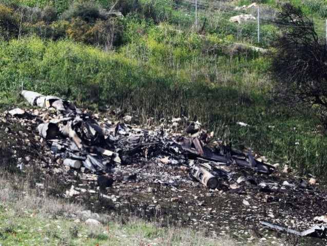israeli security forces walk next to the remains of an f 16 israeli war plane near the israeli village of harduf israel february 10 2018 photo reuters