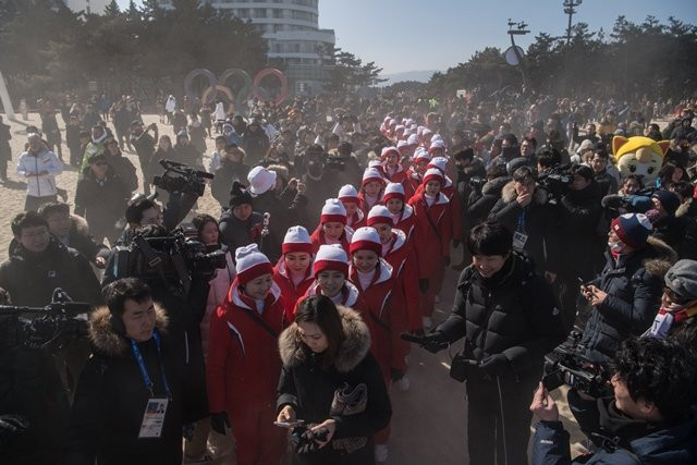 north korean cheerleaders are surrounded by media as they attempt to walk on gyeongpo beach in gangneung on february 13 2018 photo afp north korean cheerleaders are surrounded by media as they attempt to walk on gyeongpo beach in gangneung on february 13 2018 photo afp