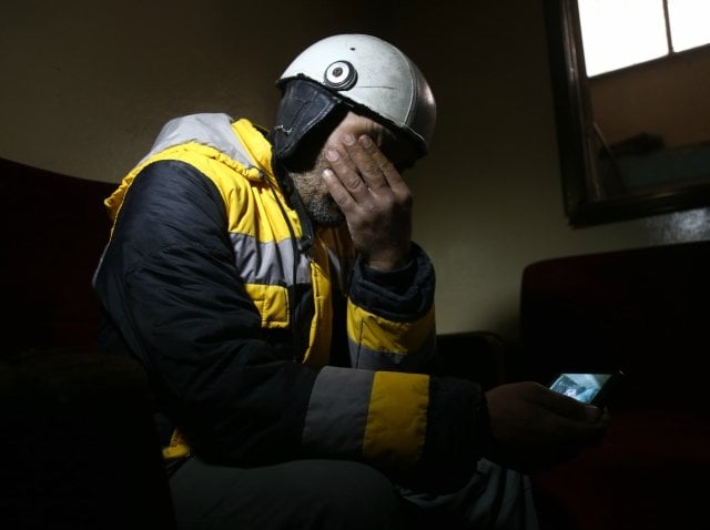 forty five year old samir salim who along with his three brothers are members of the white helmets rescue forces mourns as he looks at a picture that he took when he tried to rescue the body of his mother from under the rubble of his home in the town of medeira in syria 039 s rebel held eastern ghouta area on february 12 2018 photo afp