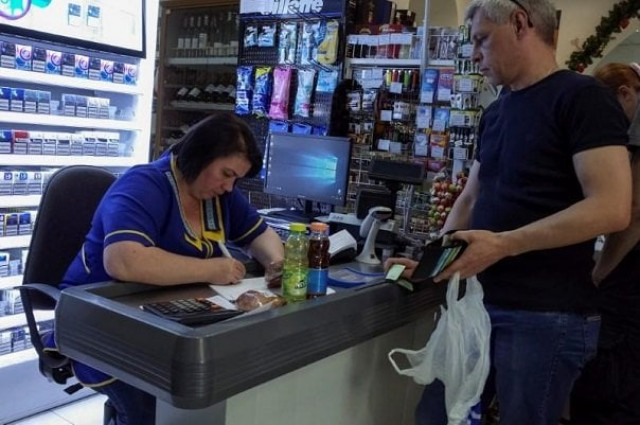 a customer waits while a cashier writes out a purchase receipt for store records as many business have turned off their digital tills after cases of cyber attacks on business at a store in kiev ukraine june 28 2017 photo reuters a customer waits while a cashier writes out a purchase receipt for store records as many business have turned off their digital tills after cases of cyber attacks on business at a store in kiev ukraine june 28 2017 photo reuters