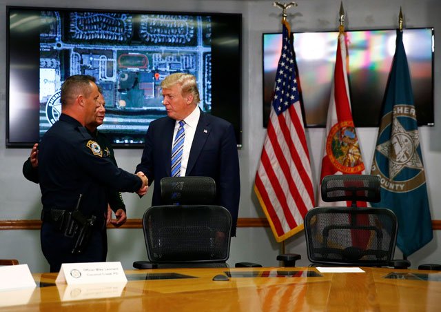 donald trump shakes hands with officer mike leonard of the coconut creek police department at the broward county sheriff 039 s office in the wake of the shooting at marjory stoneman douglas high school in fort lauderdale florida photo reuters