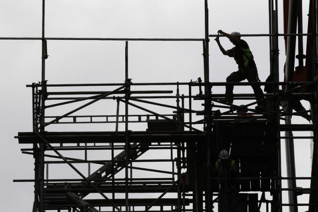 a man works on scaffolds at a construction site photo reuters a man works on scaffolds at a construction site photo reuters