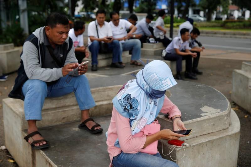 people use smartphones on a sidewalk in jakarta indonesia february 14 2018 picture taken february 14 2018 photo reuters