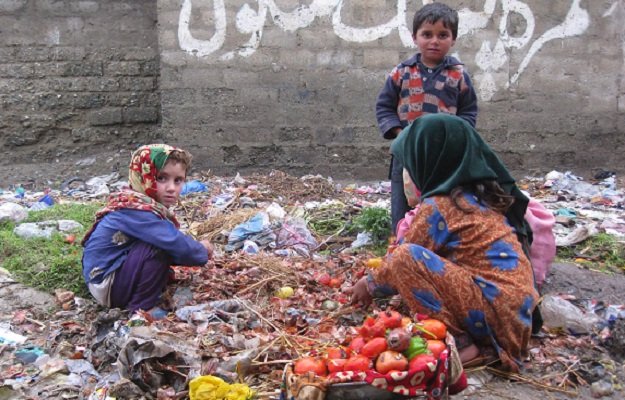 bajaur agency gypsy children searching useable vegetables from heap of garbage at khar photo inp