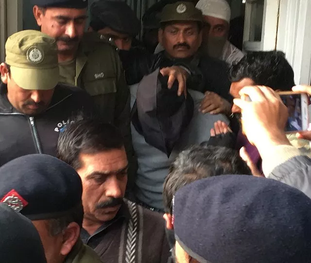 policemen escort the suspect accused of raping and murdering a young girl as they leave an anti terrorist court in lahore on january 24 2018 photo afp policemen escort the suspect accused of raping and murdering a young girl as they leave an anti terrorist court in lahore on january 24 2018 photo afp