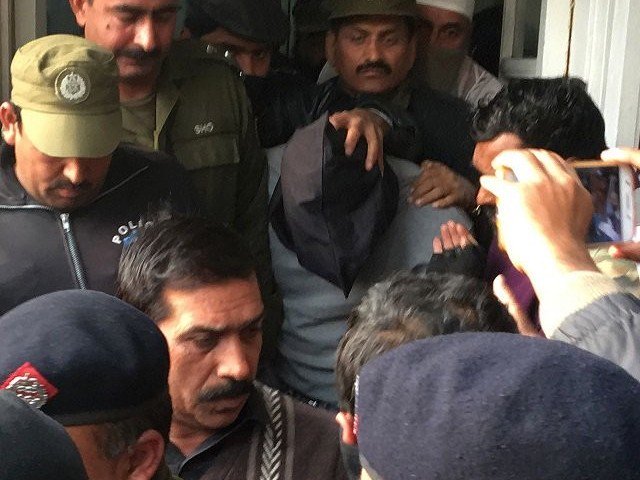 policemen escort the suspect accused of raping and murdering a young girl as they leave an anti terrorist court in lahore on january 24 2018 photo afp