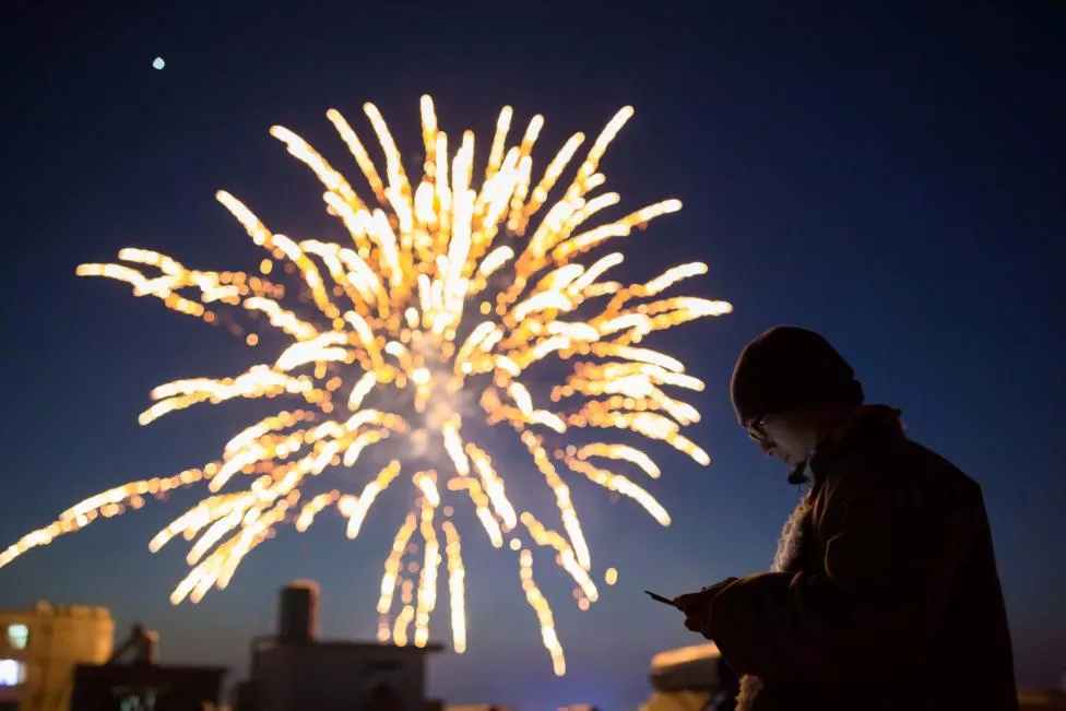 a man looks at his phone as fireworks explode on the eve of the chinese lunar new year or the spring festival in lianyungang jiangsu province china photo reuters a man looks at his phone as fireworks explode on the eve of the chinese lunar new year or the spring festival in lianyungang jiangsu province china photo reuters