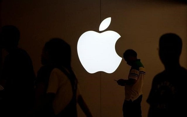 a man looks at the screen of his mobile phone in front of an apple logo outside its store in shanghai china july 30 2017 photo reuters